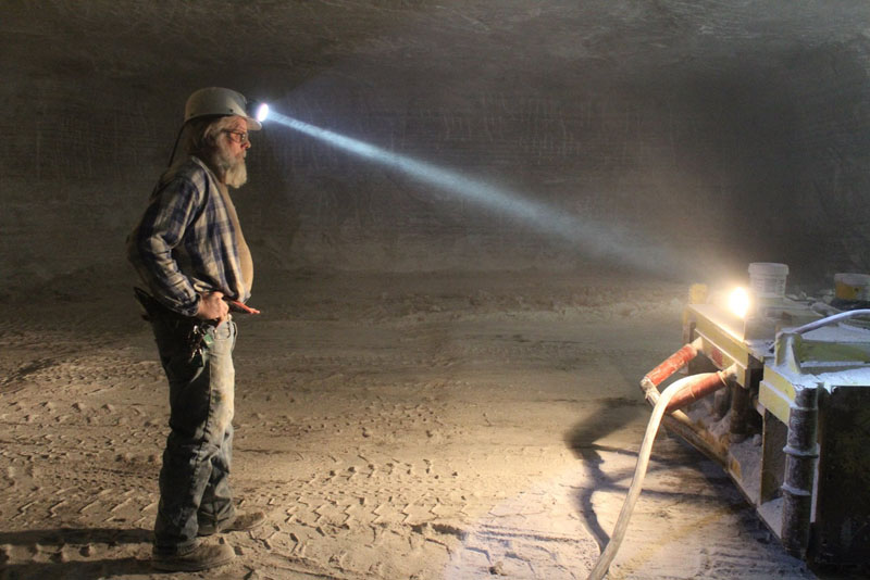 Miner with headlamp working underground at 650 feet